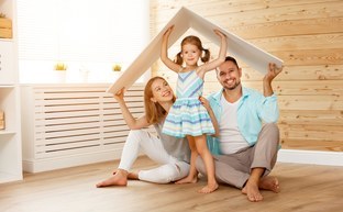 concept housing young family. Mother father and child in new house with roof concept housing a young family. Mother father and child in new house with a roof